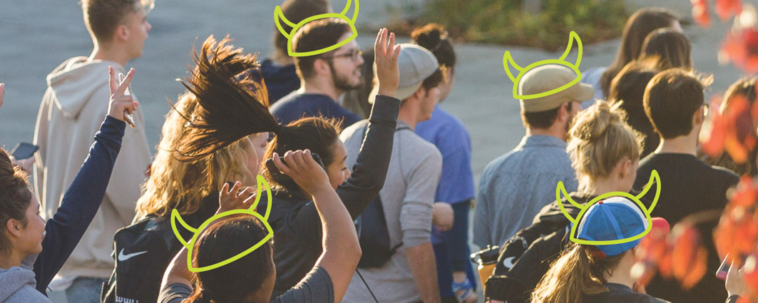 A photo of students celebrating coming back to campus with horned "viking" helmets drawn on their heads.